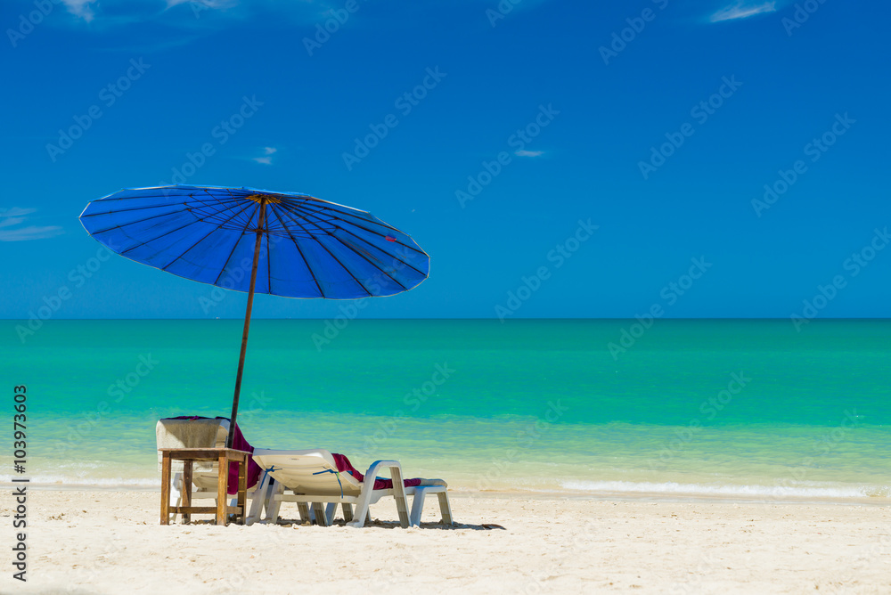  lounge chairs with sun umbrella on a beach