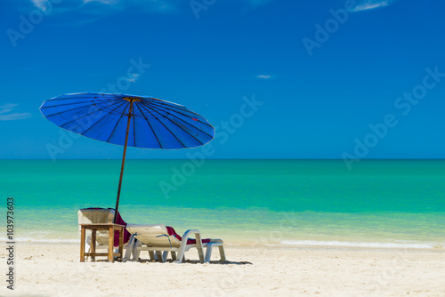  lounge chairs with sun umbrella on a beach