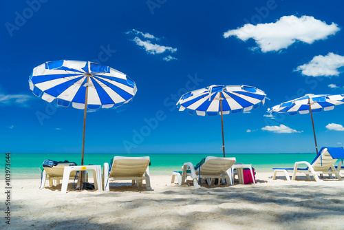  lounge chairs with sun umbrella on a beach