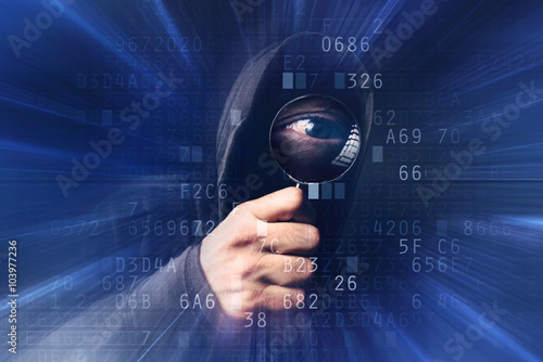 Spyware software, hooded hacker with magnifying glass analyzing