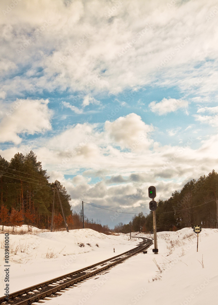 snowy railway and traffic light in winter near forest. snowy railway and traffic light in winter near forest.