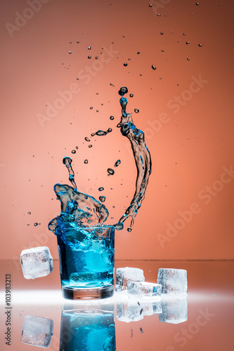 Eiswürfel fallen in ein Glas photo