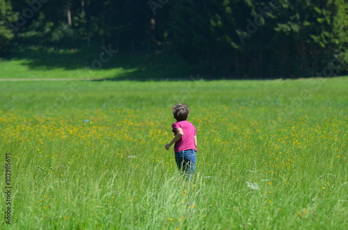 Kind rennt in Wiese