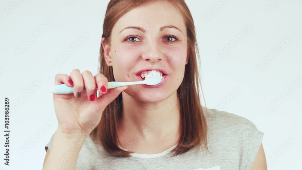 Woman in bathroom brushing her teeth with a toothbrush. Close-up. Woman in bathroom brushing her teeth with a toothbrush. Close-up.