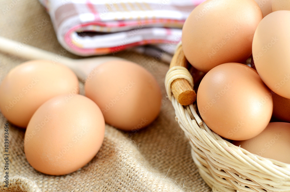 Wicker basket with eggs on a linen tablecloth Wicker basket with eggs on a linen tablecloth