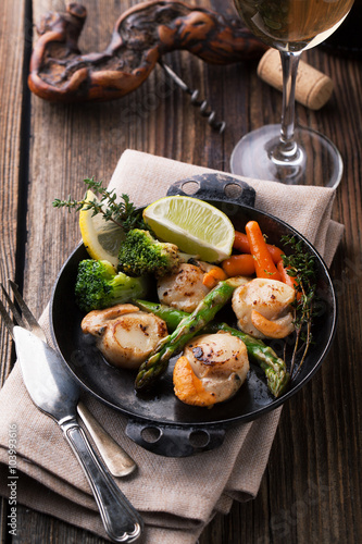 Fried scallops in a sauce with asparagus and broccoli