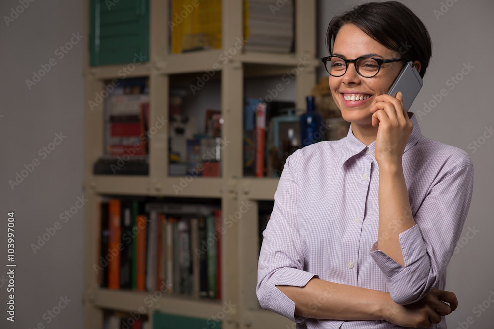 Attractive young woman with glasses talks on her smartphone Attractive young woman with glasses talks on her smartphone
