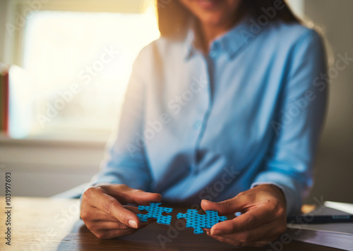 Business woman connecting puzzles