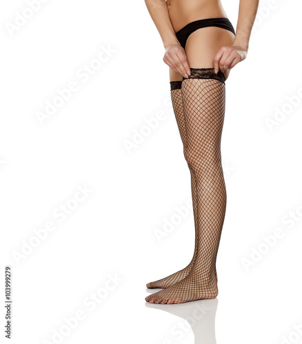 women pull on her fishnet stockings