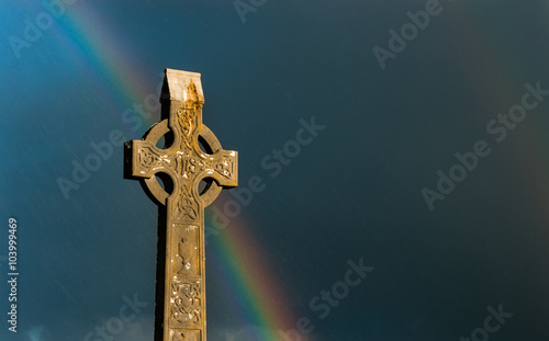 Konstfotografi Rainbow sky behind celtic cross gravestone at sunset