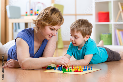 Family playing board game at home on the floor at home