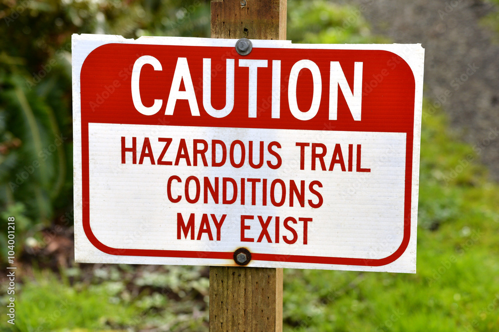 a trail sign stating that hazardous conditions may exist ahead