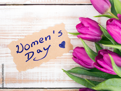 Women's day card and a bouquet of beautiful tulips on wooden background