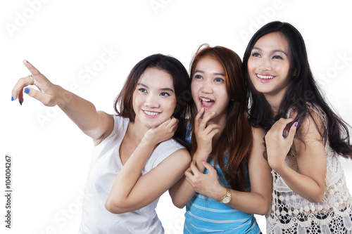 Pretty teenage girls pointing copy space