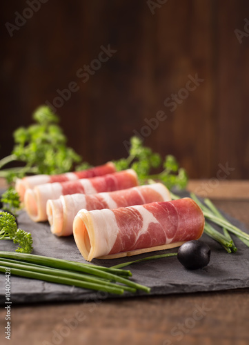 Delicious sliced bacon on wooden table