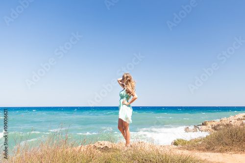 summer holidays and vacation concept - girl standing on the beach