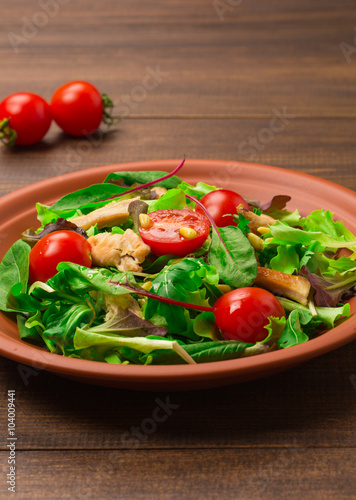 Fresh salad with chicken breast, arugula and tomato.