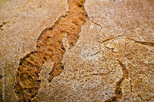  rye bread on a wooden table with ripe ears of whea photo