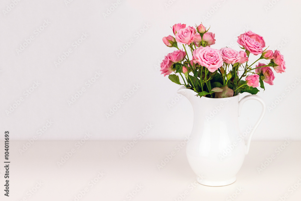 Fototapeta premium Pink flowers in white jug. Roses in jug.