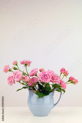 Fototapeta Naklejka Na Ścianę i Meble -  Pink flowers in blue jug. Roses in jug.