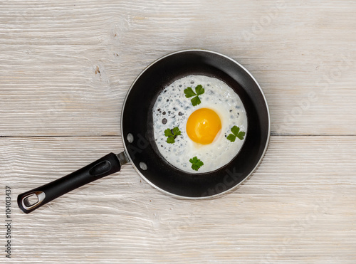 pan with fried eggs on a wooden background