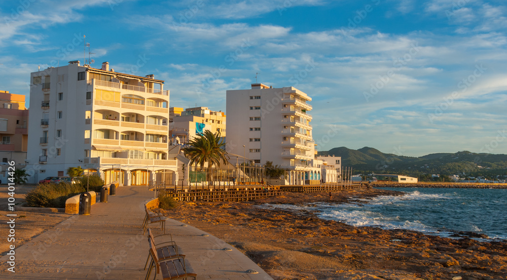 Obraz premium Sunset on the Cafes on Ibiza beaches. Golden glow. People watch as the sun goes down in St Antoni de Portmany Balearic Islands, Spain.