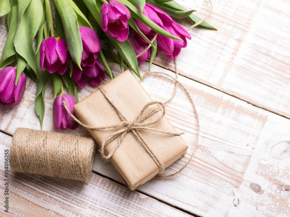 Gift box and tulips bouquet on white wooden background - retro style Gift box and tulips bouquet on white wooden background - retro style