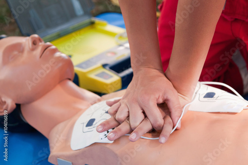 Hands of a paramedic doing chest compression during defibrillator CPR training photo