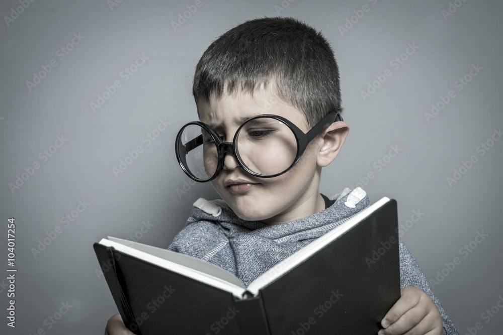 kid, dark-haired young student reading a funny book, reading and kid, dark-haired young student reading a funny book, reading and