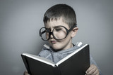 kid, dark-haired young student reading a funny book, reading and