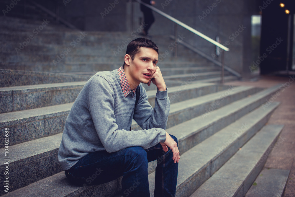 Toughtful man sitting on steps.