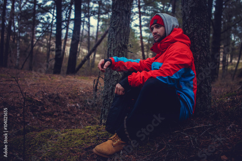 A man in red jacket in the forest. © Fxquadro