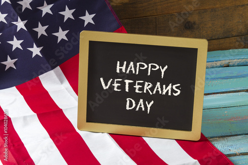 veterans day chalk sign on blue wood background with flag