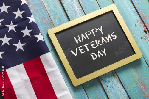 veterans day chalk sign on blue wood background with flag