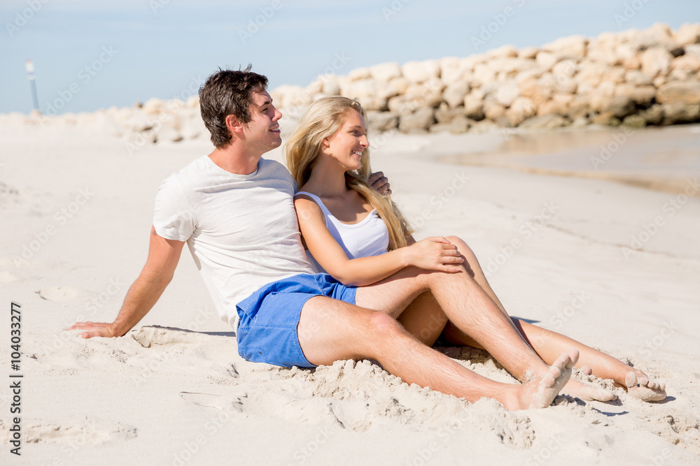 Romantic young couple sitting on the beach