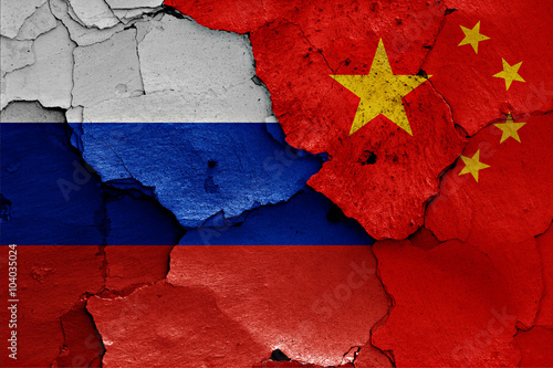 flags of Russia and China painted on cracked wall