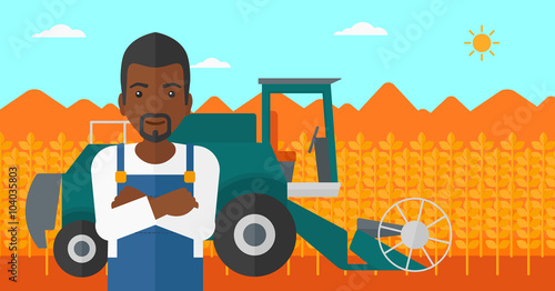Man standing with combine on background.