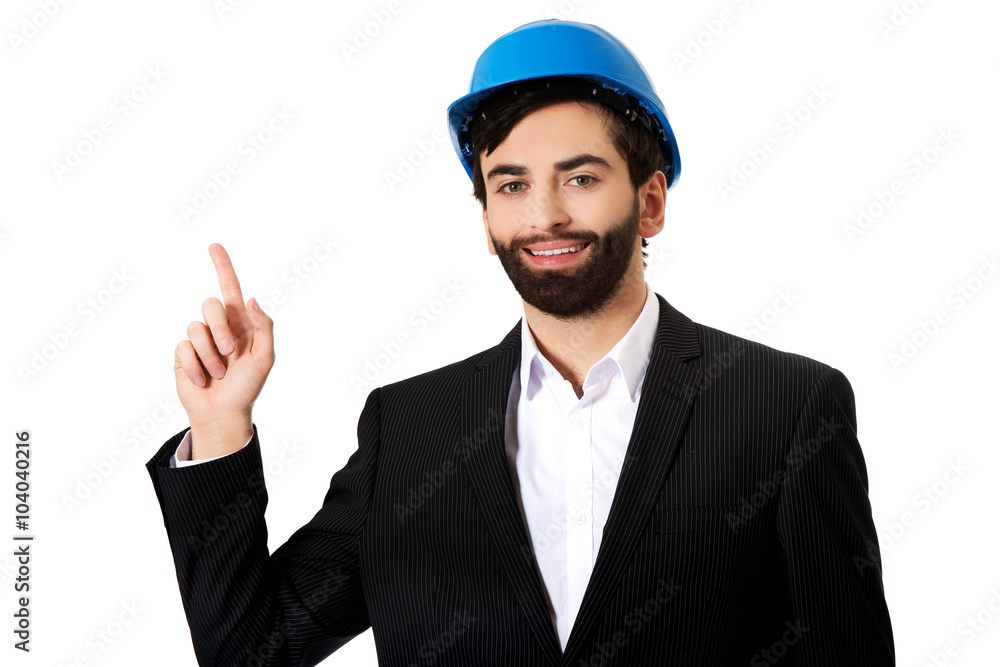 Engineer in protective helmet pointing up.
