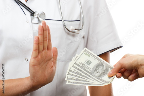 Woman doctor refusing bribes or kickbacks, concept of corruption