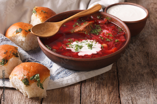 Ukrainian borscht red soup with garlic buns on the table. horizontal
