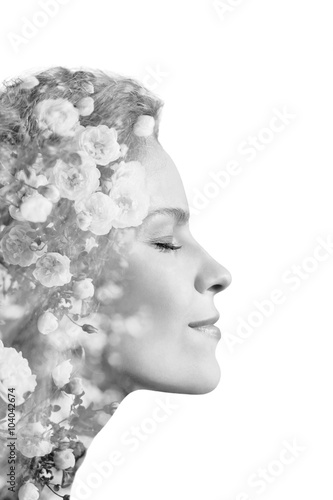 Creative portrait of beautiful young woman made from double exposure effect using photo of roses flowers, isolated on white background, monochrome © juliasudnitskaya