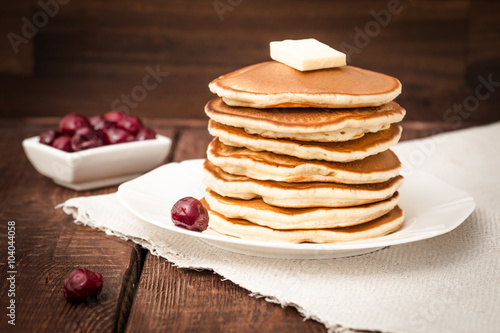 pancakes with cherry and butter on a dark background
