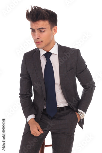 side view of a serious young business man sitting on a chair
