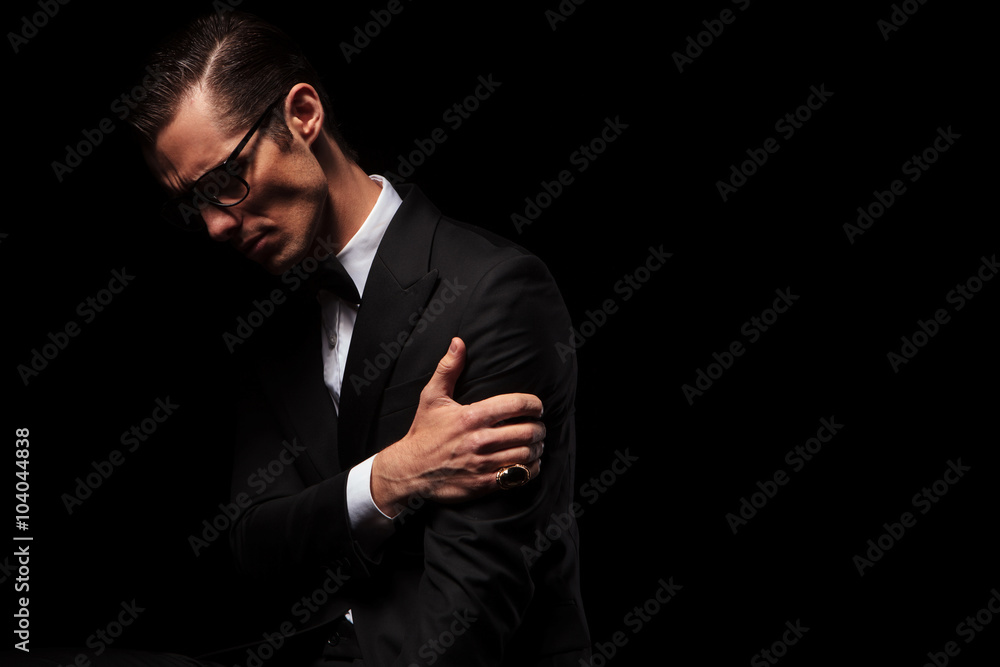 classy smart man in black suit posing looking down