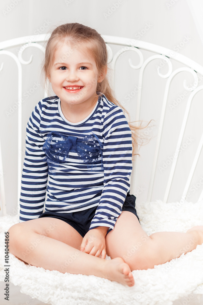 Fototapeta premium Happy little girl in striped shirt on white background