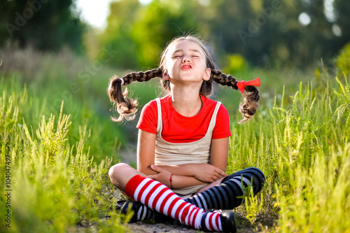 Konstfotografi girl with pigtails imagines the summer on the nature