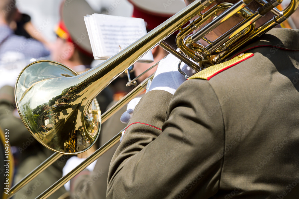 Obraz premium military musician playing gold trombone on parade
