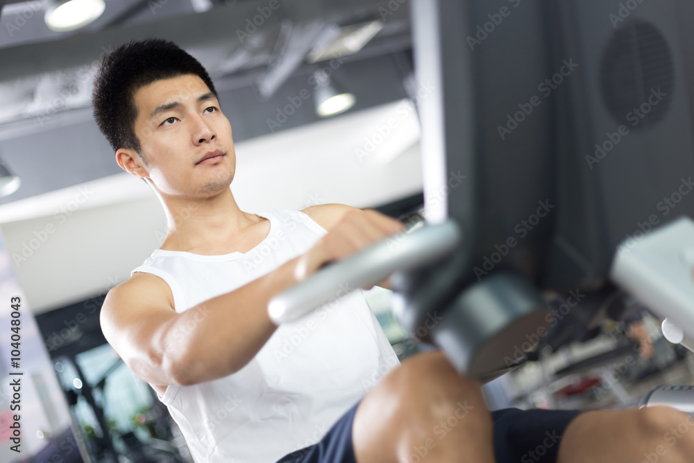 Fototapeta premium young handsome man working out in modern gym