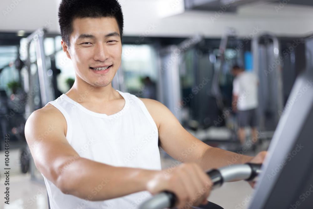 Fototapeta premium young handsome man working out in modern gym