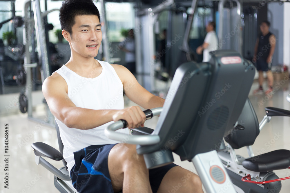 Fototapeta premium young handsome man working out in modern gym
